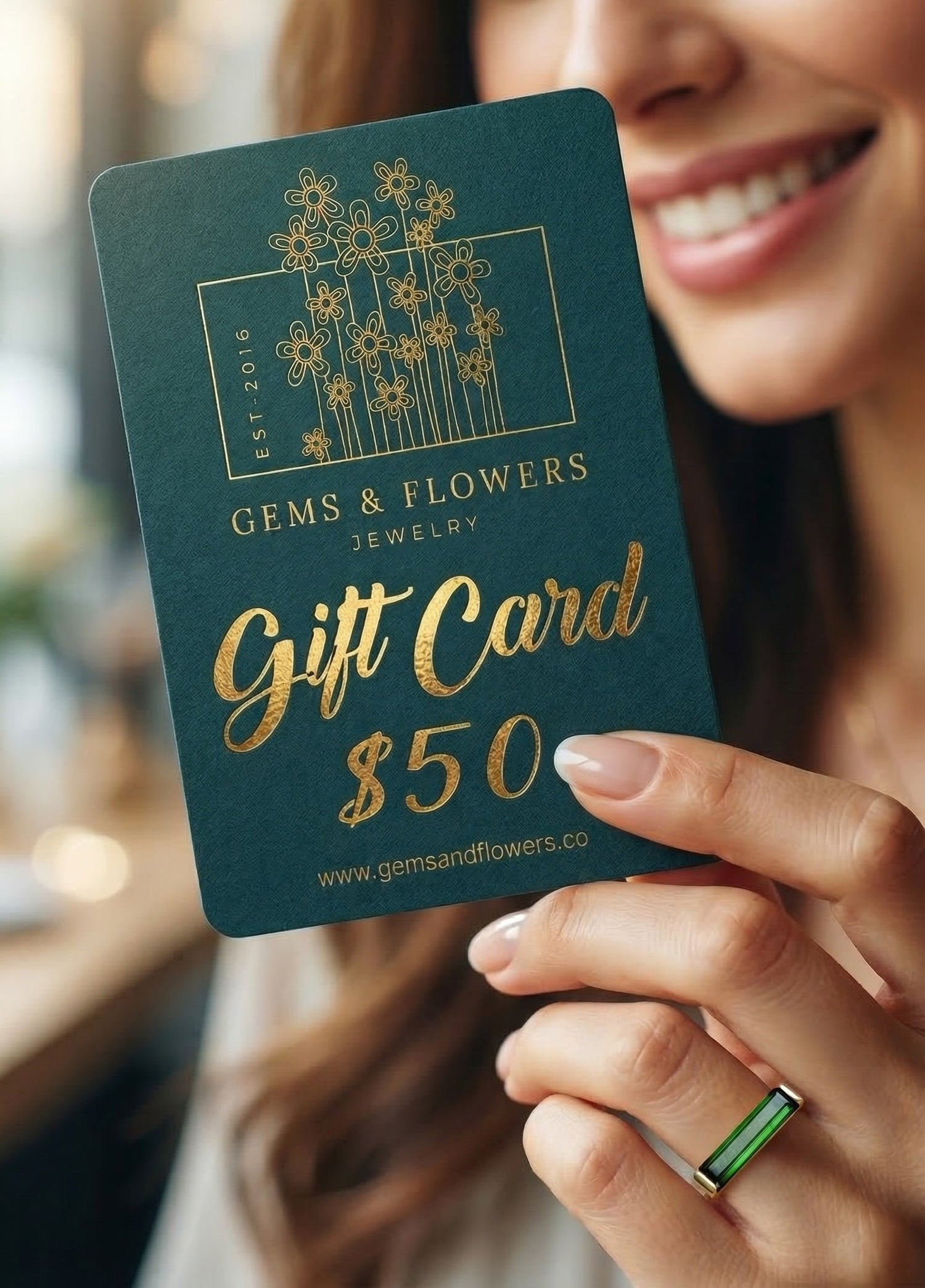 a woman with a ring is holiding a gift card for Gems & Flowers jewelry brand