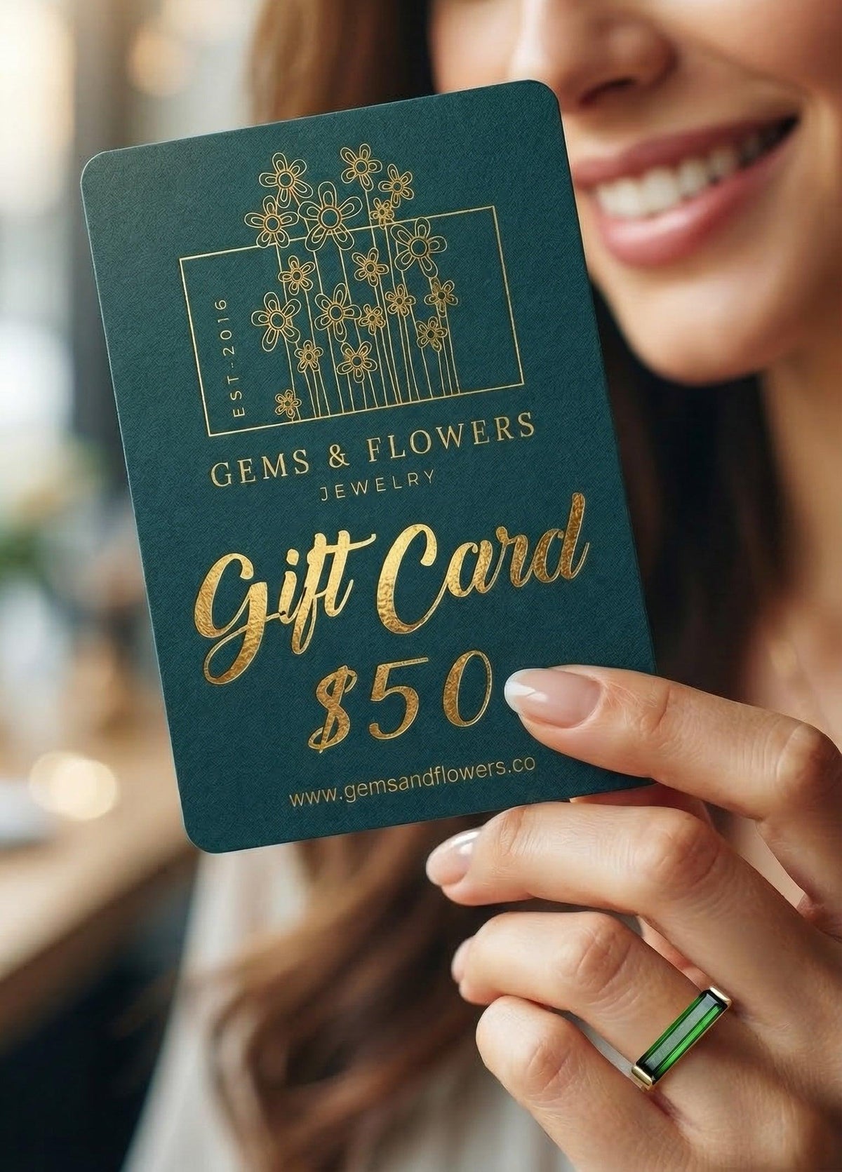 a woman with a ring is holiding a gift card for Gems & Flowers jewelry brand