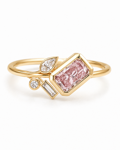 A gold ring featuring a large rectangular pink diamond center stone, accented by smaller diamonds in marquise and baguette settings, shown on a clean white background.