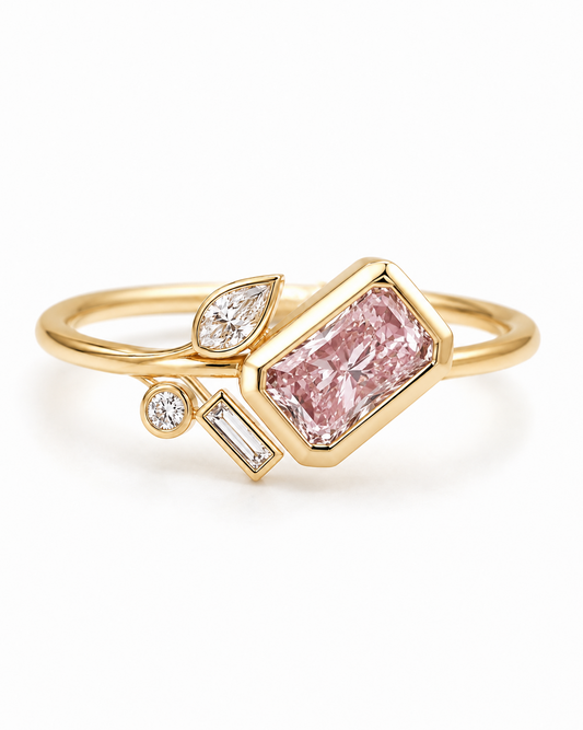A gold ring featuring a large rectangular pink diamond center stone, accented by smaller diamonds in marquise and baguette settings, shown on a clean white background.