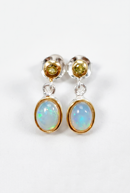 Pair of earrings with opal and yellow gemstones on a white background